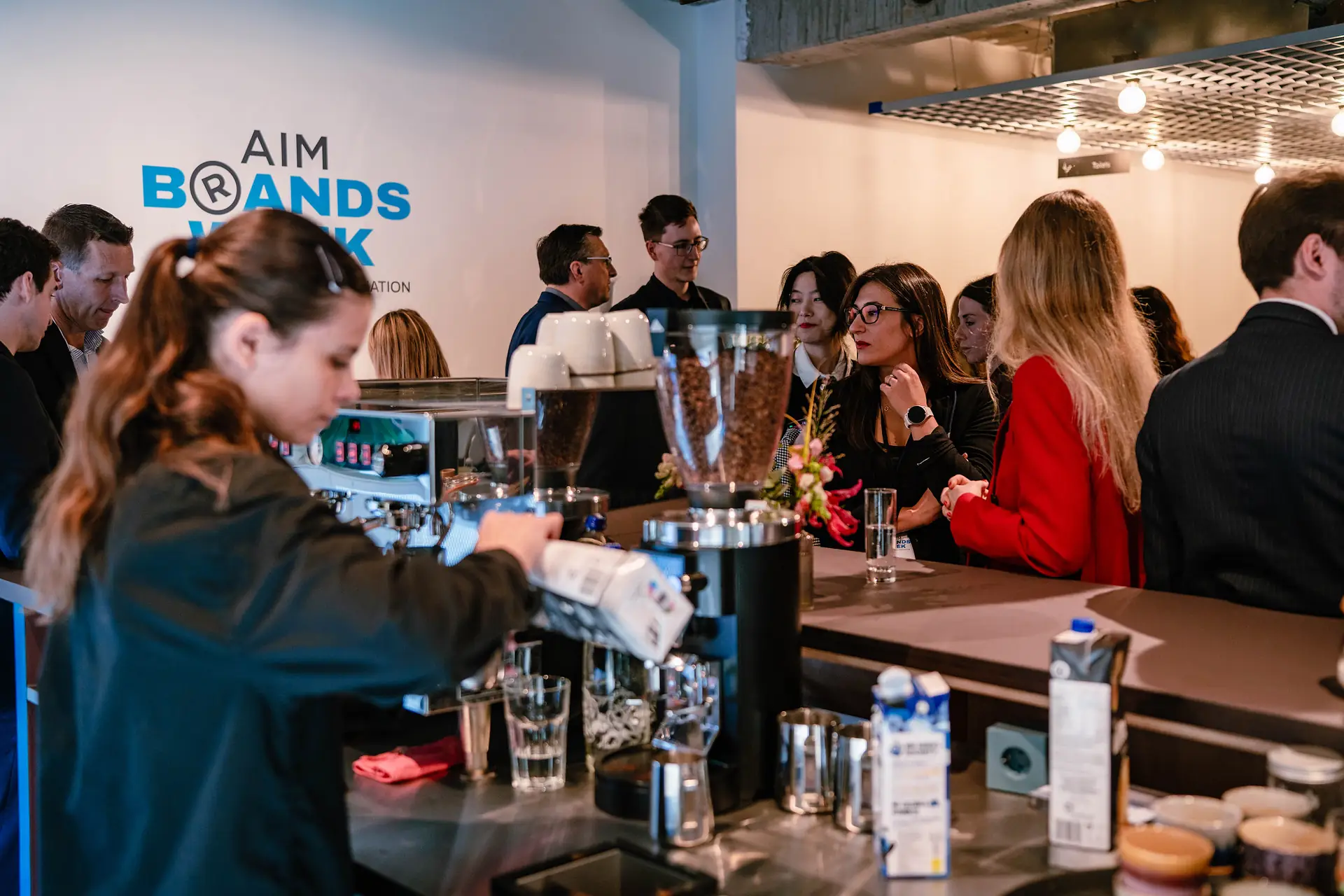 A busy coffee bar beneath the AIM Brands Week logo