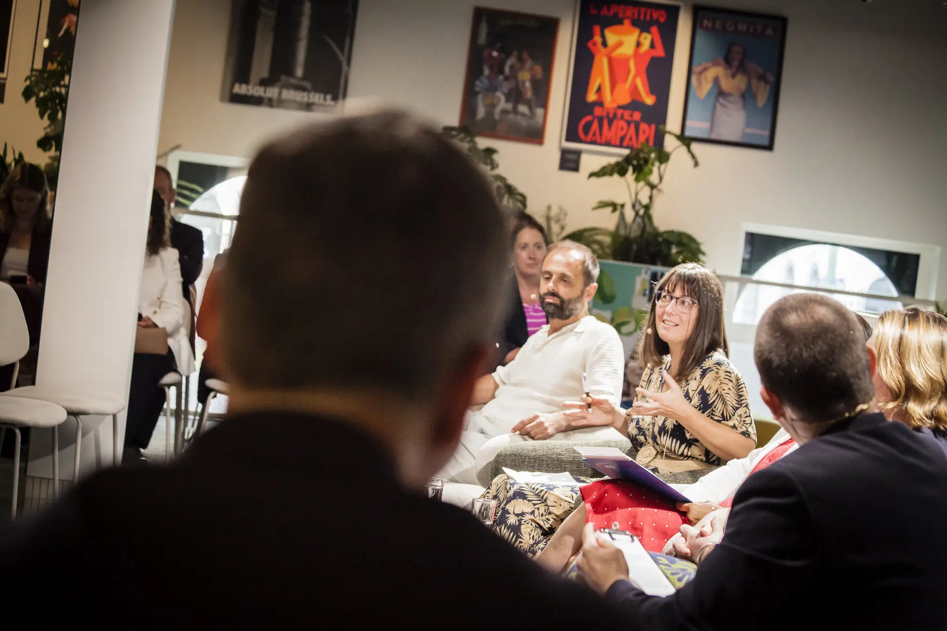 A panel discussion in the round, with guests on lounge seating