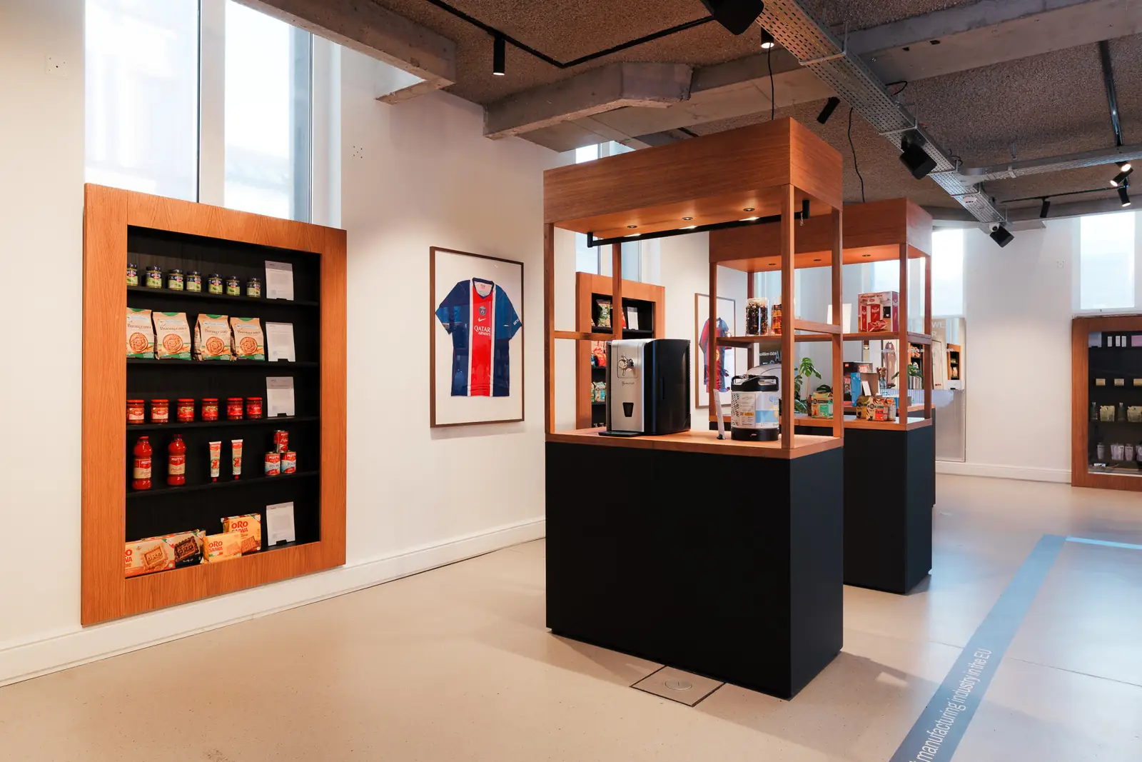 Display cabinets of branded products, with a framed football shirt on the wall