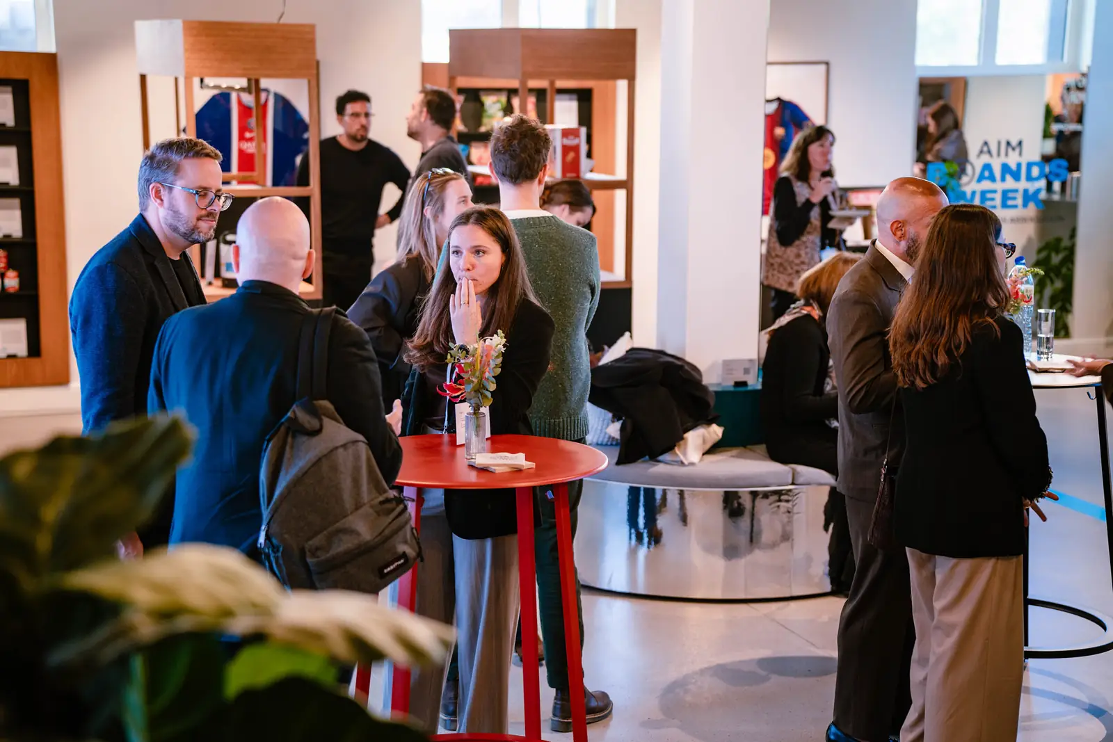 Guests mingling round high tables during a break