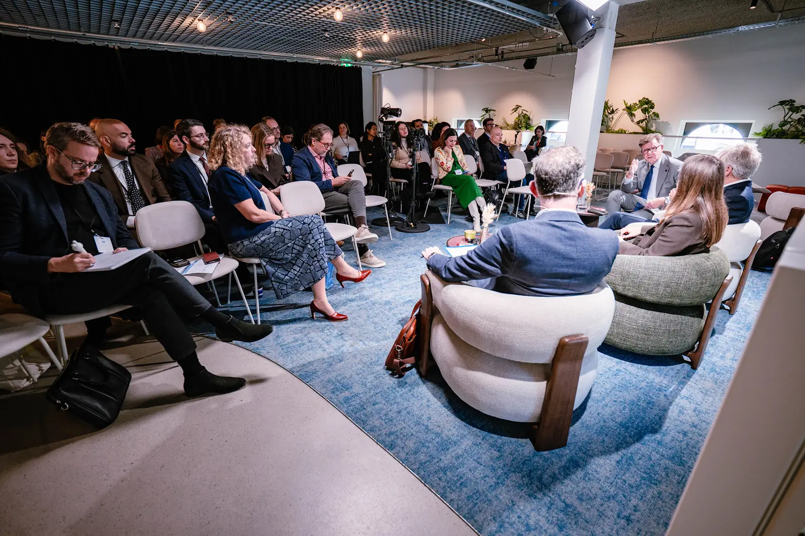 A seated audience during a panel in the lounge setting