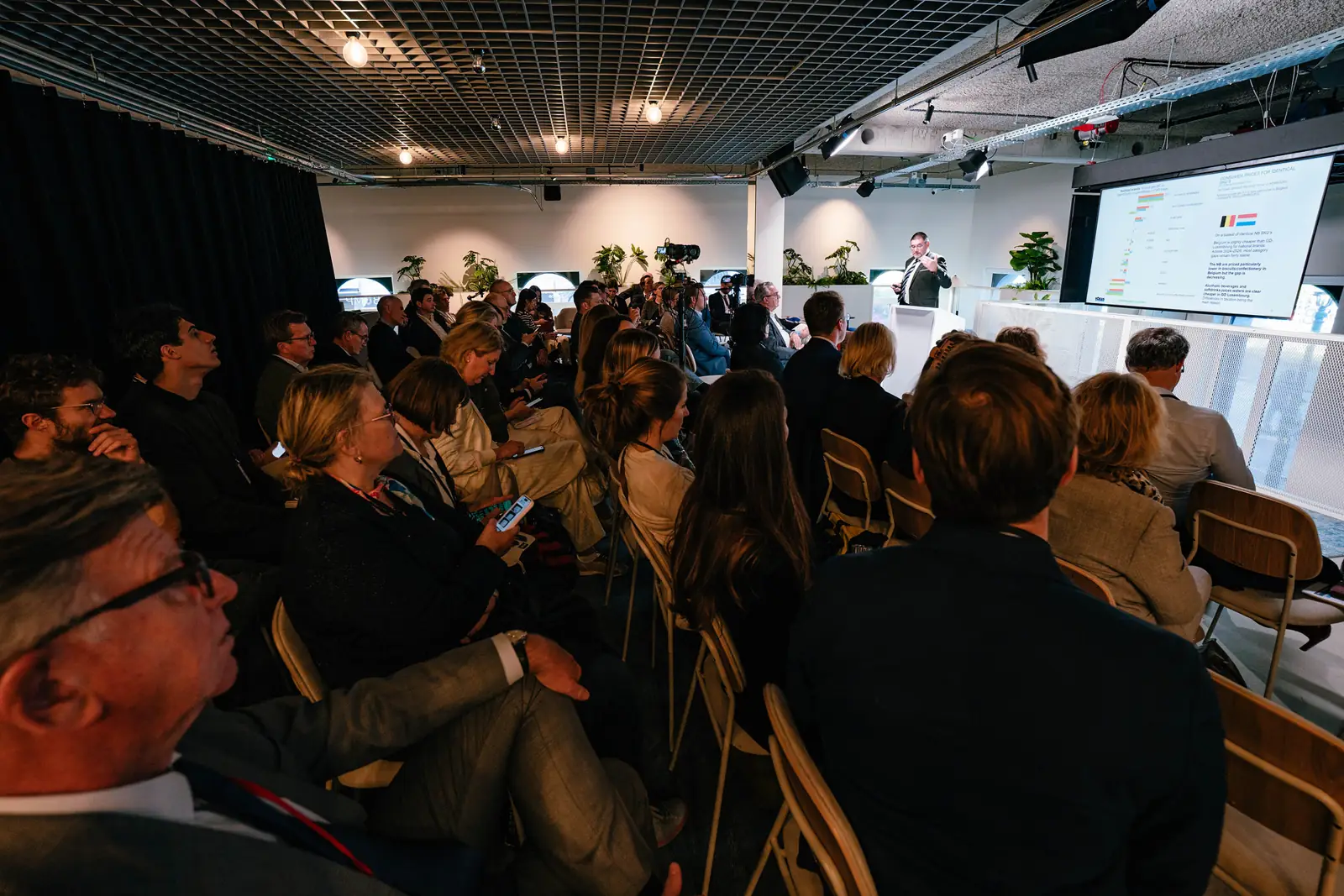 A full room listening to a session, with slides on the screen