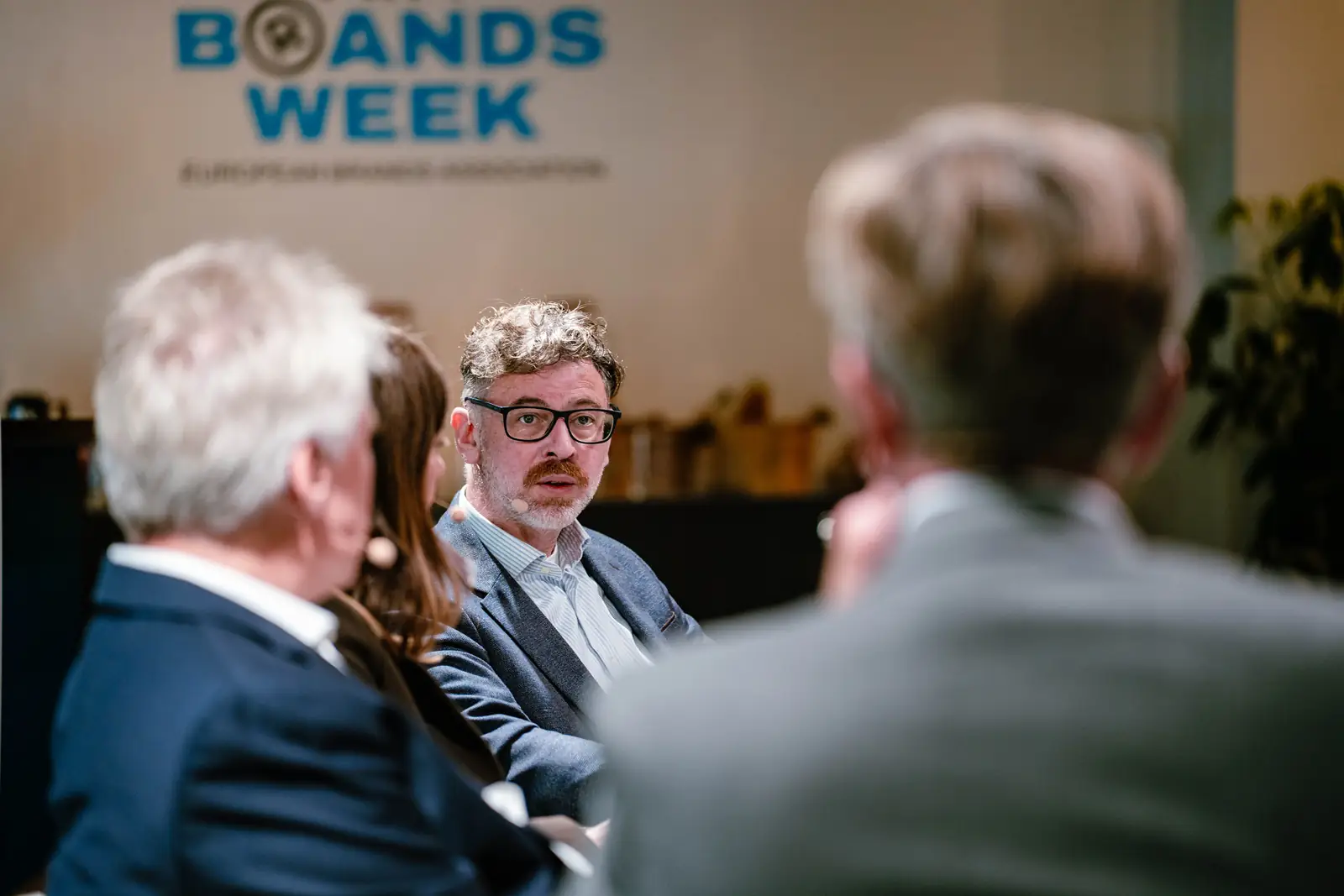 Guests in conversation beneath the Brands Week logo