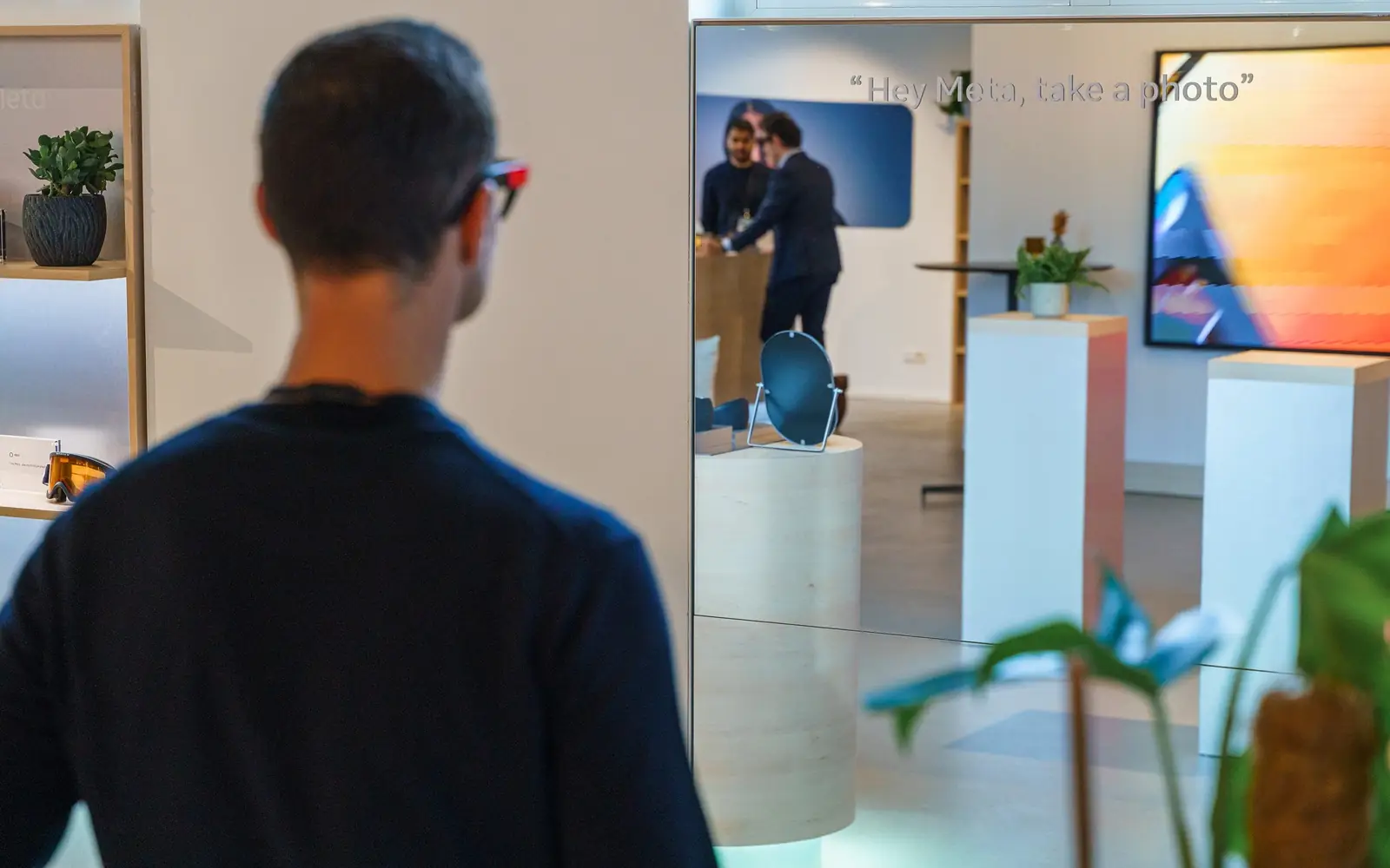 A guest wearing AI glasses, with &ldquo;Hey Meta, take a photo&rdquo; on the screen beyond