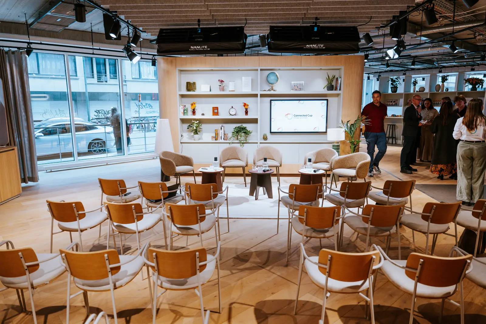 Rows of chairs set for a session, facing a screen and the shelving wall