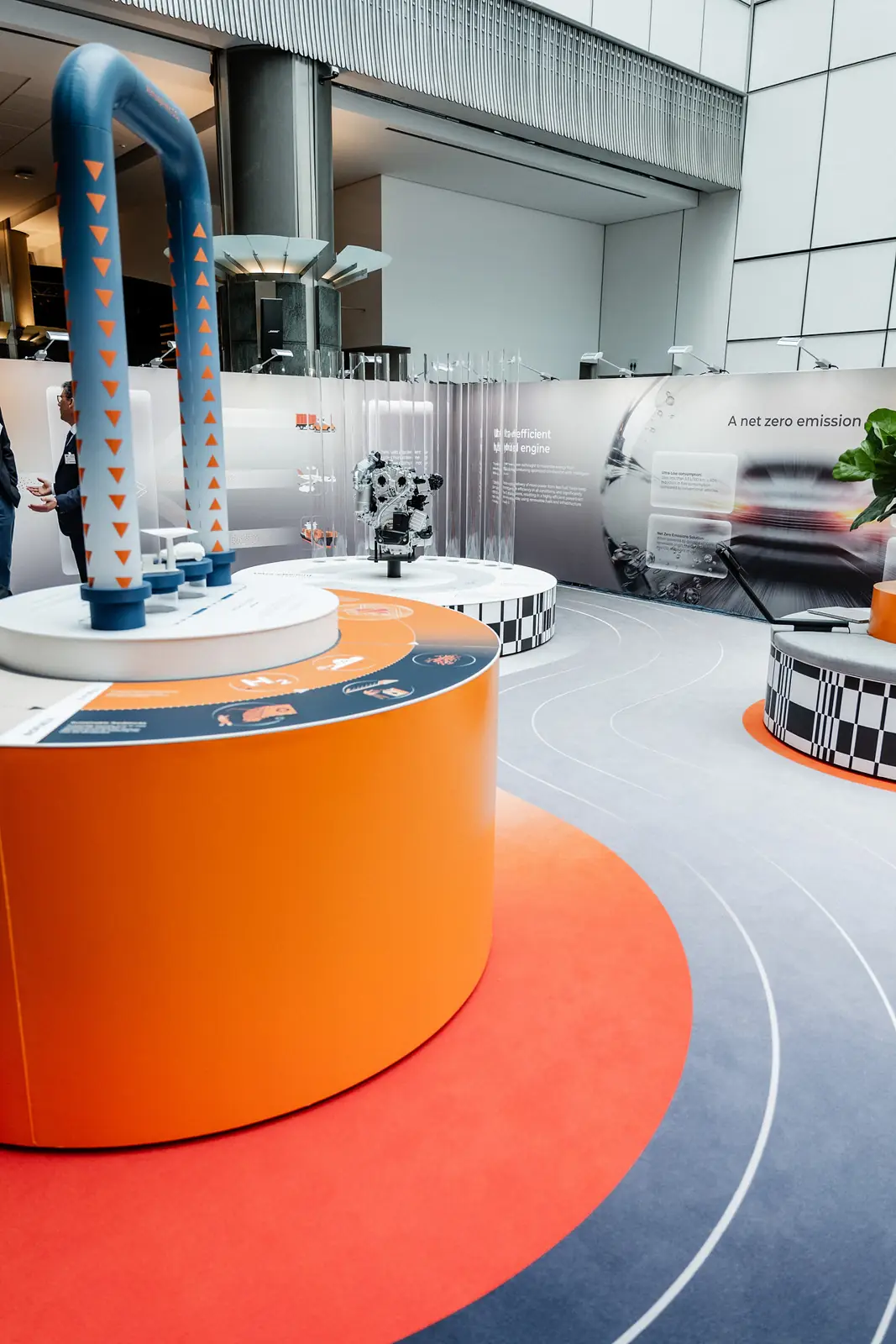 The orange plinth and the curving floor graphic leading round the stand