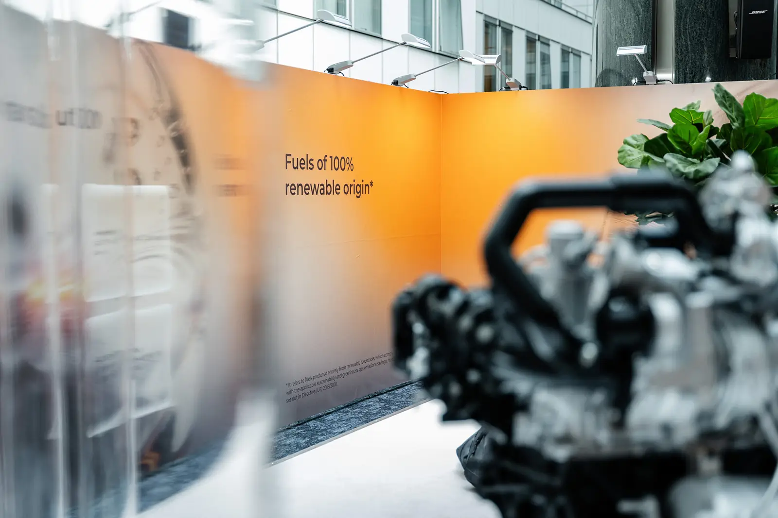 A wall reading &ldquo;Fuels of 100% renewable origin&rdquo;, with the engine blurred in the foreground