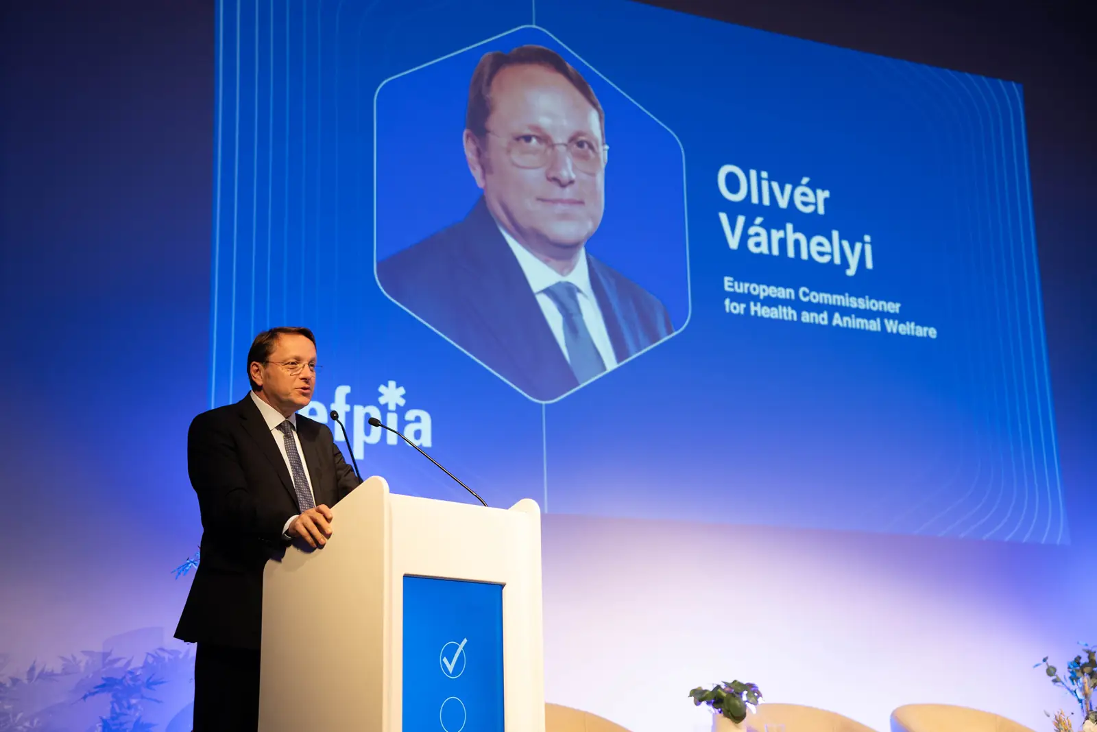 European Commissioner Ol&iacute;ver V&aacute;rhelyi giving a keynote at the EFPIA lectern