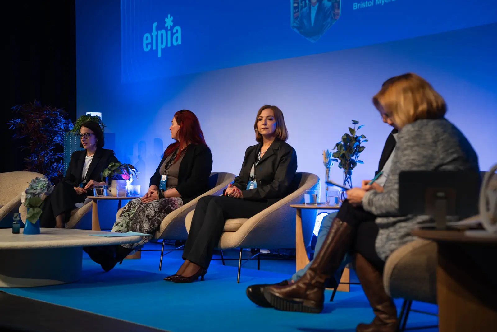 Four panellists on the blue-lit stage