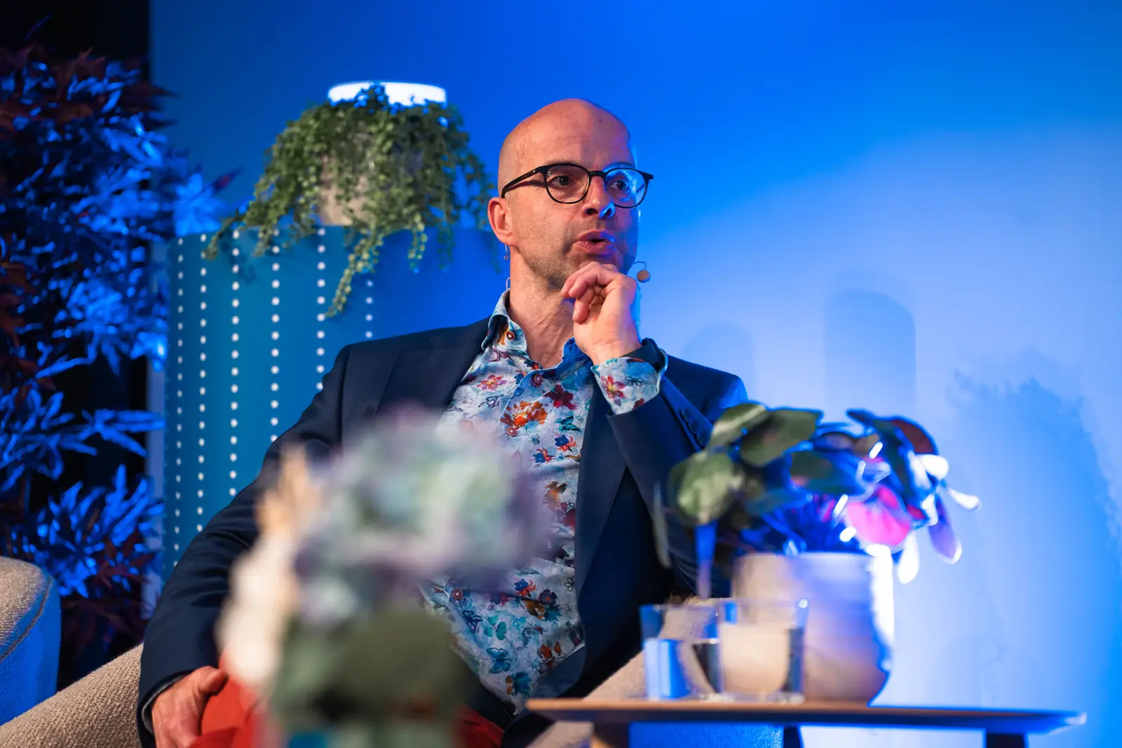 A panellist listening on the blue-lit stage