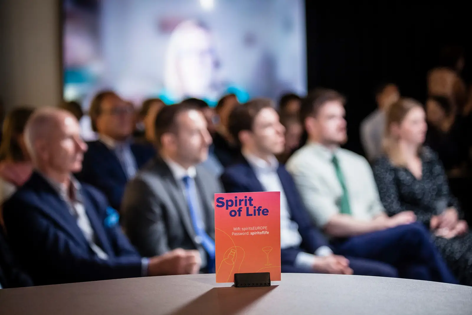 Guests seated for a talk, with a Spirit of Life table card in the foreground
