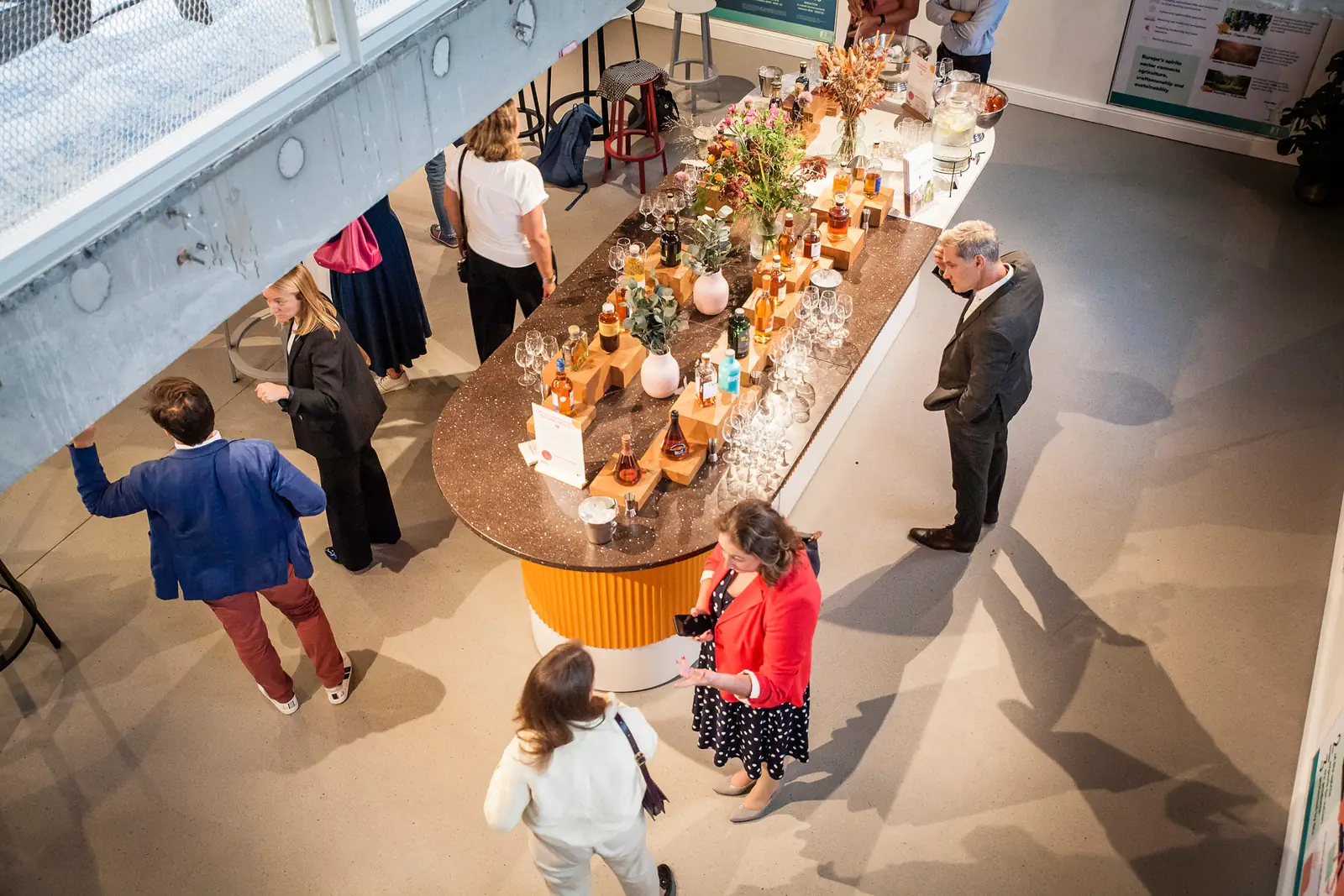 Guests gathering round a long tasting bar, seen from above