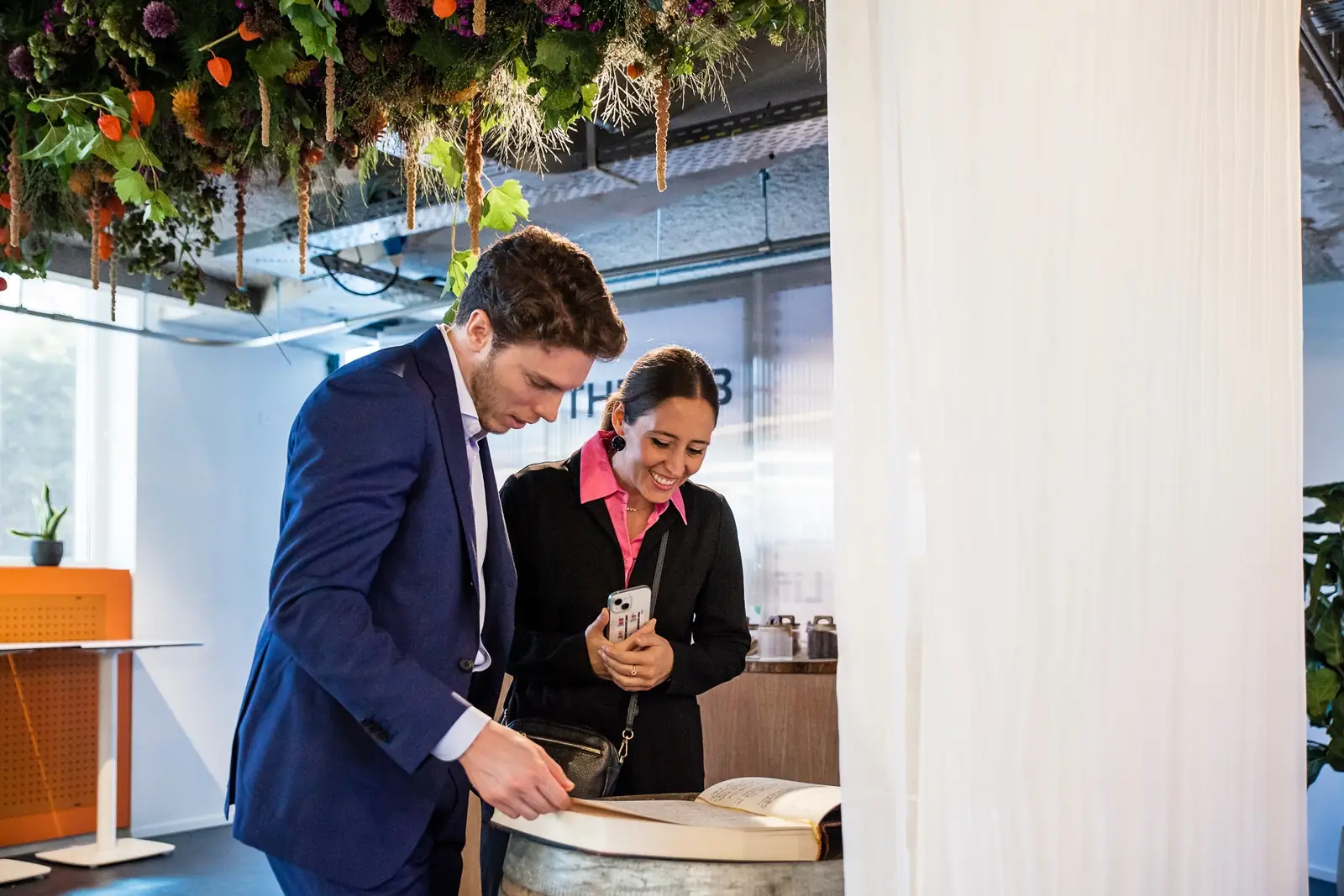 Two guests leafing through a book set on a barrel