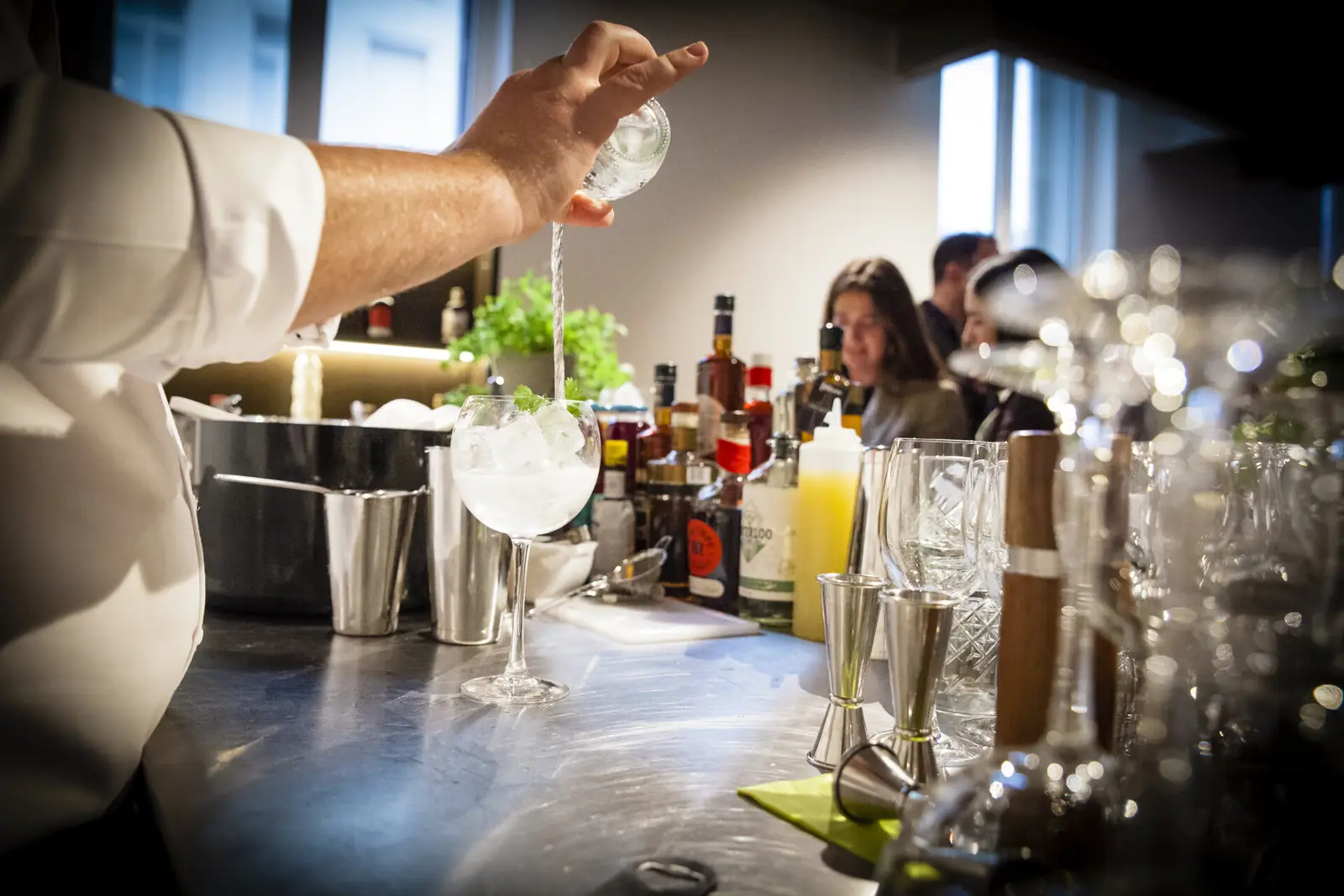 A bartender pouring a drink at the cocktail bar