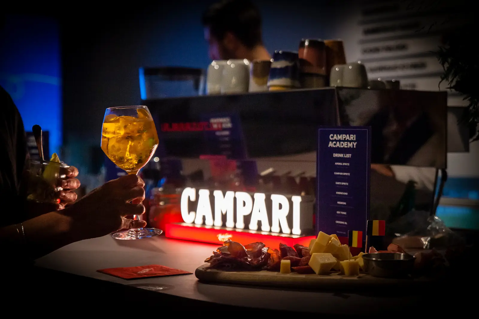 A spritz at the Campari bar, beside a board of cheese and charcuterie