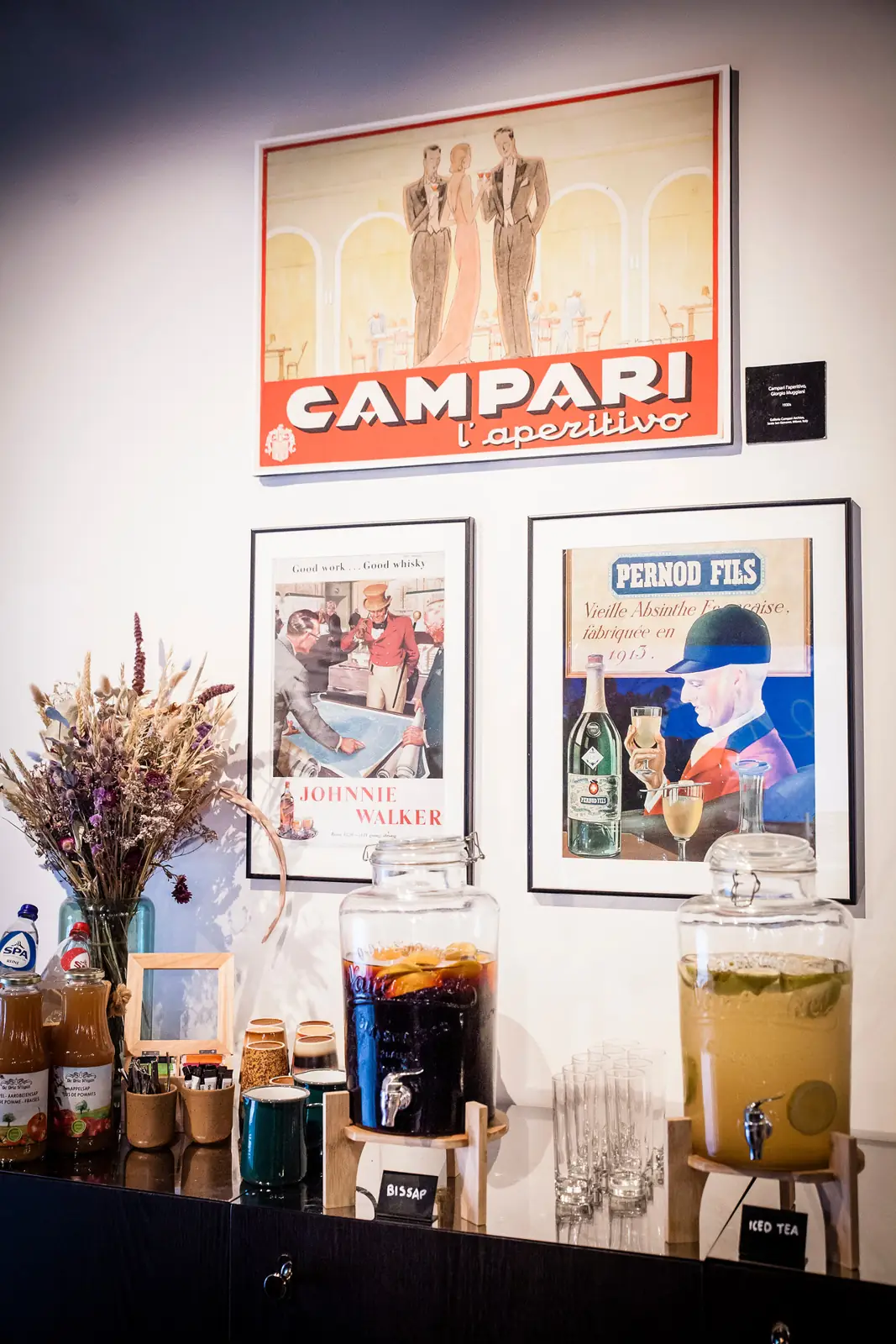 Vintage Campari and Pernod Fils posters above a drinks station