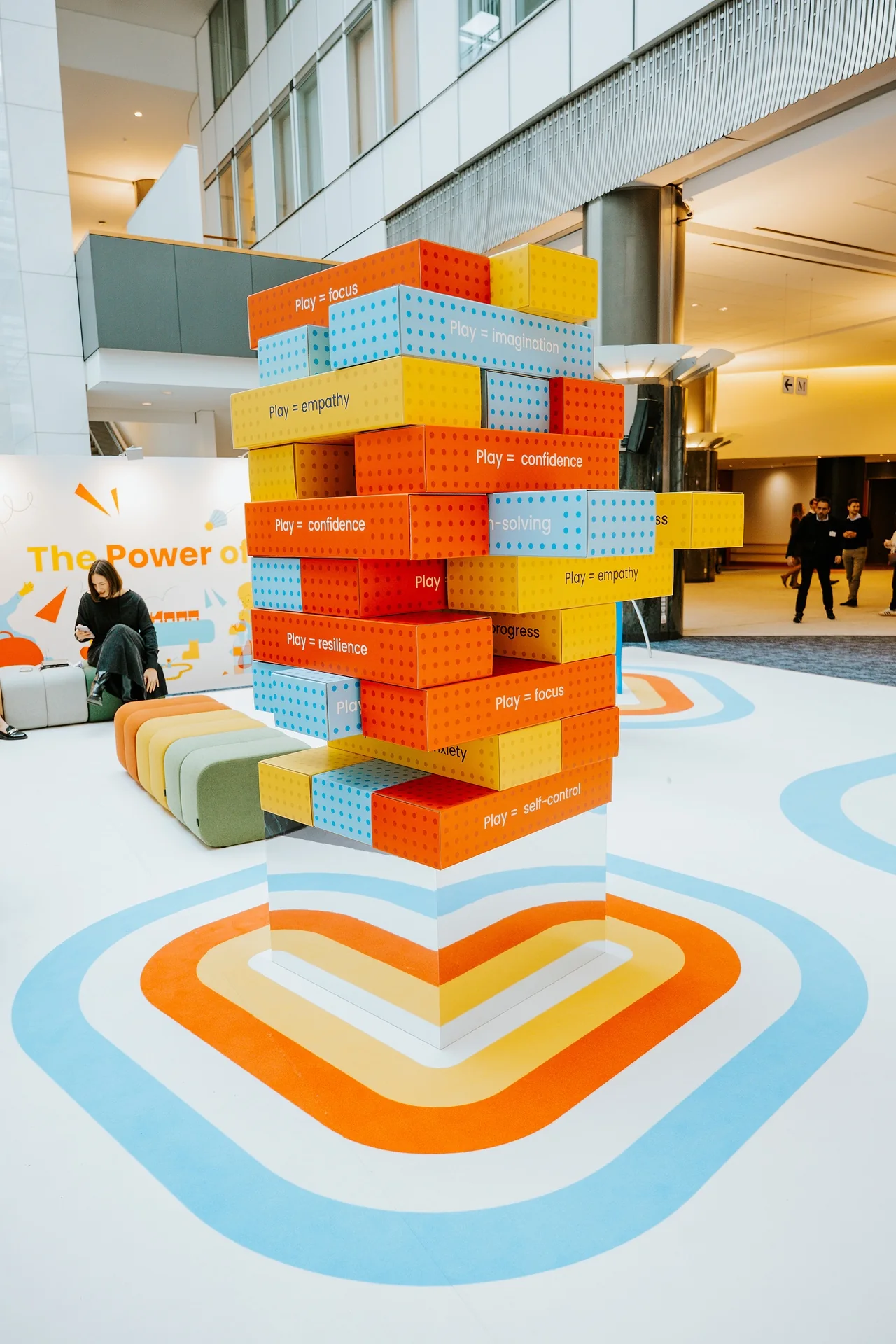 The block tower beside the seating, with the exhibition title behind