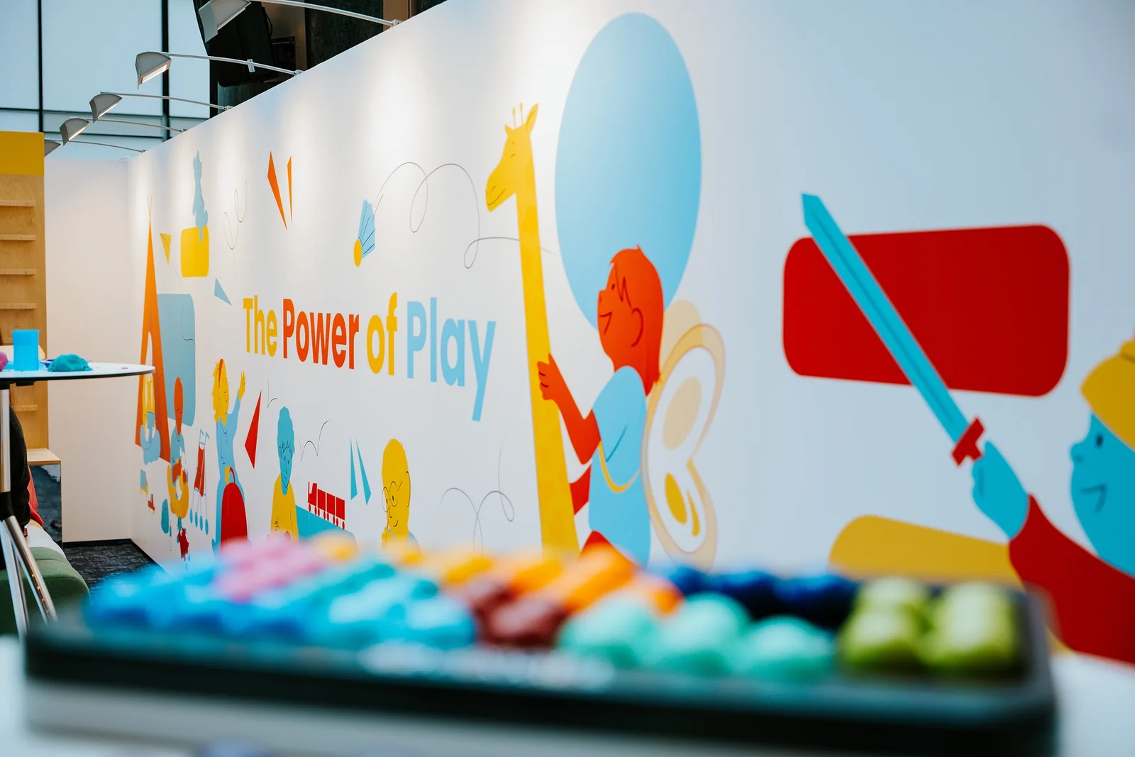 A xylophone in front of the illustrated Power of Play wall